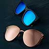 Fashionable sun glasses on a dark blue background with copy space. Modern accessory for protection eyes.