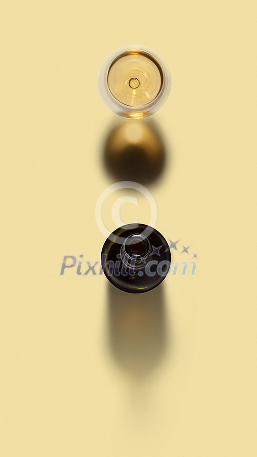 Alcohol drink set from opened wine bottle and glass of white wine on a light yellow background with soft shadows and copy space. Top view.