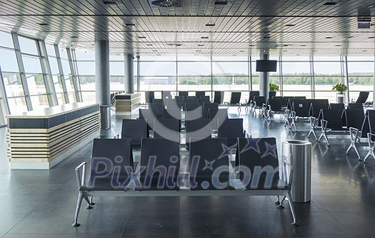 Modern airport terminal with empty arm-chairs for waiting departure. Travel and transportation concept.