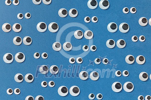 Googly plastic eyes used to imitate eyeballs for craft toys and dolls and others creativity on a blue backgroud. Top view. Googly plastic eyes used to imitate eyeballs for craft toys and dolls and others creativity on a blue backgroud. Top view.