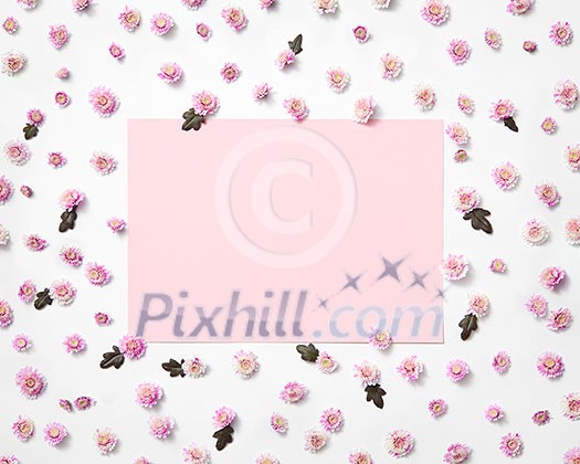 Blossoming floral photo frame from small flowers with green leaves with light pink rectangular paper area, copy space. Flat lay. Valentine's Day concept. Blossoming floral photo frame from small flowers with green leaves with light pink rectangular paper area, copy space. Flat lay. Valentine's Day concept.