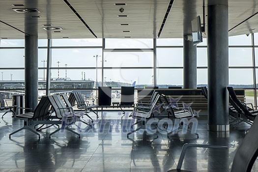 Empty hall at airport with comfortable chairs for waiting departure. Travel and transportation concept.