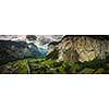 Pretty, female climber on a via ferrata - climbing on a rock in Swiss Alps