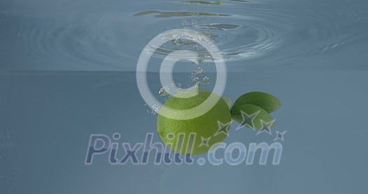 Natural ripe fresh lime with green leaf is swimming under water in a glass container on a grey background. Slow motion 2K video. Natural ripe fresh lime with green leaf is swimming under water in a glass container on a grey background. Slow motion 2K video.