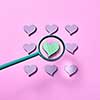 Big loupe is increesing size of green heart around other lavender colored hearts on a pastel pink background, copy space. Valentine's day greeting card.