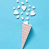 Paper cone with small white gypsum hearts as ice-cream sweet dessert on a pastel blue background with soft shadows, copy space. Valentine's day greeting card.
