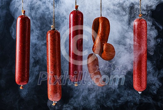 Smokehouse. The process of smoking sausage. Smoked sausages hang in a cupboard with smoke. 