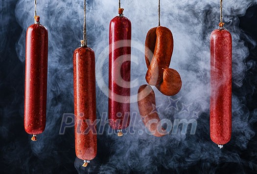 Smokehouse. The process of smoking sausage. Smoked sausages hang in a cupboard with smoke. Smokehouse. The process of smoking sausage. Smoked sausages hang in a cupboard with smoke.