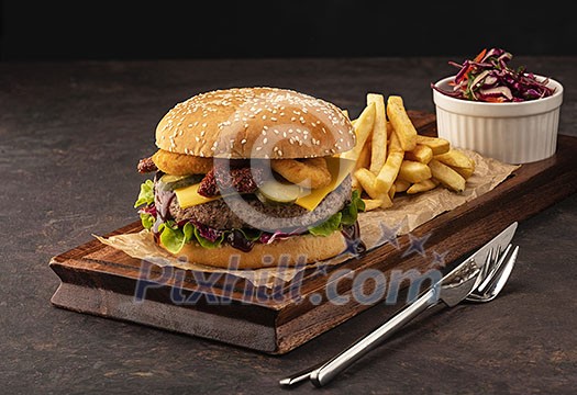 Juicy homemade cheeseburger in a black bun with onion rings and dried tomatoes. Beef Burger with Cheese and Salad Juicy homemade cheeseburger in a black bun with onion rings and dried tomatoes. Beef Burger with Cheese and Salad