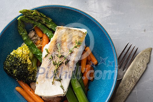 Pike perch fillet with asparagus, broccoli and carrots. Fried fish with stewed greens.