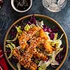 Salad with warm glazing chicken, sprinkled with sesame seeds. Chinese cuisine. Asian culture.