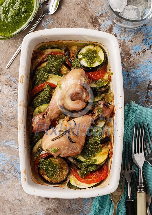 Ratatouille with chicken and pesto. French cuisine. Rosemary chicken with oven-roasted ratatouille. Top view. Ratatouille with chicken and pesto. French cuisine. Rosemary chicken with oven-roasted ratatouille. Top view.