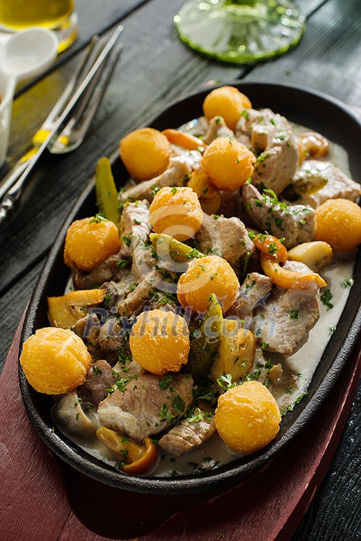 Slices of pork and rabbit liver with mushrooms in sour cream sauce garnished with potato balls Slices of pork and rabbit liver with mushrooms in sour cream sauce garnished with potato balls