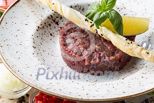 Fresh tasty beef tartare. Minced meat with ingredients for tartar.