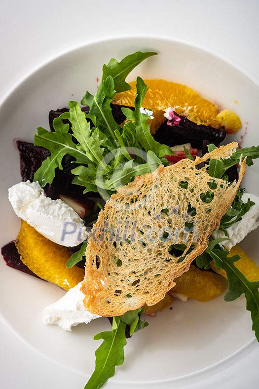 Salad with dried beetroot, apple, orange and soft goat cheese