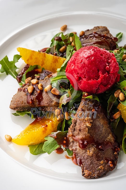 Salad with rabbit liver, Parmesan, raspberry sorbet and pine nuts. Top view.