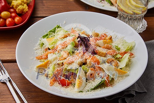 Seafood Salad with Cheese on wooden table. Salmon Salad with Shrimps on white plate.