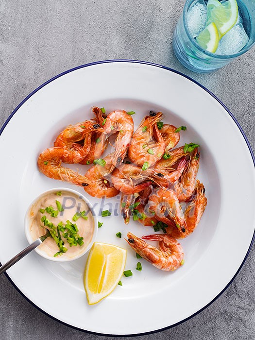 Shrimp glazed in soy sauce with green onion and lemon. Top view.