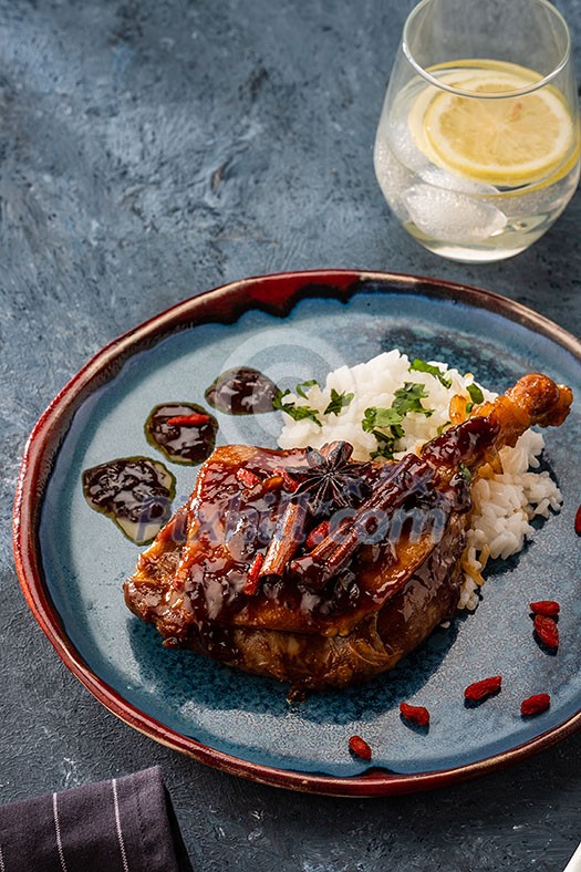 Duck leg confit with rice and goji berries. Traditional french cuisine. View from above.