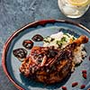 Duck leg confit with rice and goji berries. Traditional french cuisine. View from above.