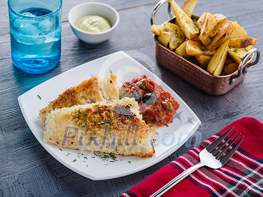 Fried fish with tomato-olive sauce and potatoes