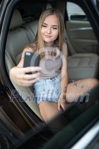 Cute teenage girl listening to her favorite music/audiobook on hig-end headphones during a roadtrip