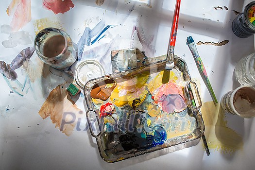 Palette and paint brush in artist hands. Artist paints oil picture with paint brush in hand palette close-up. Artist painting holding palette and paint brush in hand. Artists paintbrush with palette. Palette and paint brush in artist hands. Artist paints oil picture with paint brush in hand palette close-up. Artist painting holding palette and paint brush in hand. Artists paintbrush with palette.