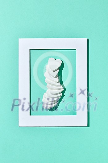 Greeting Valentine's holiday frame with gypsum hearts chain on a pastel turquoise background with hard shadows, copy space. Top view. Congratulation postcard. Greeting Valentine's holiday frame with gypsum hearts chain on a pastel turquoise background with hard shadows, copy space. Top view. Congratulation postcard.