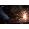 welder with protective mask welding steel structures and bright sparks in construction industry