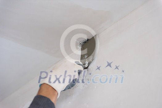 young professional construction worker plastering on gypsum walls inside the new big modern two levels apartment young professional construction worker plastering on gypsum walls inside the new big modern two levels apartment