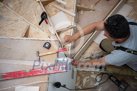 work in progress on stylish interior professional carpenter installing wooden stairs in big modern two level luxury apartment work in progress on stylish interior professional carpenter installing wooden stairs in big modern two level luxury apartment