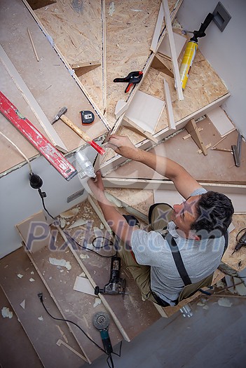work in progress on stylish interior professional carpenter installing wooden stairs in big modern two level luxury apartment work in progress on stylish interior professional carpenter installing wooden stairs in big modern two level luxury apartment