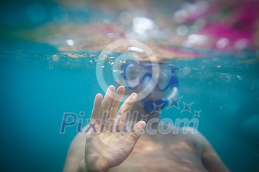 Young man having fun and taking underwater selfie while swimming in the sea Young man having fun and taking underwater selfie while swimming in the sea