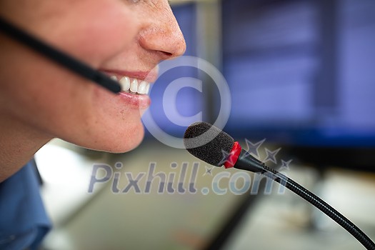 Call centre employee communicating over phone using an external microphone for better sounf and ergonomics Call centre employee communicating over phone using an external microphone for better sounf and ergonomics