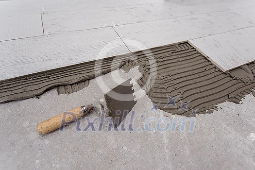 Ceramic wood effect tiles and tools for tiler on the floor unfinished laying floor tiles Floor tiles installation Ceramic wood effect tiles and tools for tiler on the floor unfinished laying floor tiles Floor tiles installation