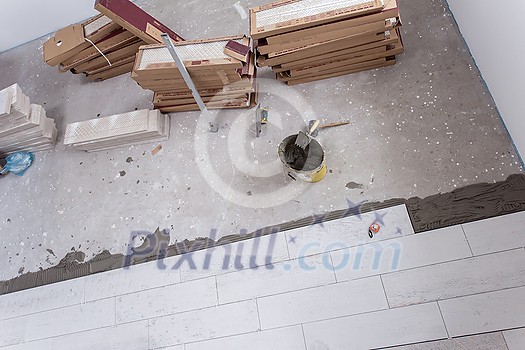 Ceramic wood effect tiles and tools for tiler on the floor unfinished laying floor tiles Floor tiles installation Ceramic wood effect tiles and tools for tiler on the floor unfinished laying floor tiles Floor tiles installation