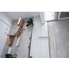 skilled worker installing the ceramic wood effect tiles on the floor Worker making laminate flooring on the construction site of the new apartment