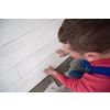 skilled worker installing the ceramic wood effect tiles on the floor Worker making laminate flooring on the construction site of the new apartment