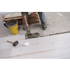 skilled worker installing the ceramic wood effect tiles on the floor Worker making laminate flooring on the construction site of the new apartment