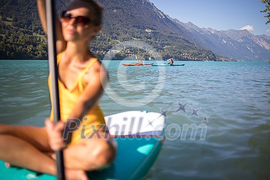 SUP Stand up paddle board concept - Pretty, young woman paddle boarding on a lovely lake in warm late afternoon light - shot from underwater SUP Stand up paddle board concept - Pretty, young woman paddle boarding on a lovely lake in warm late afternoon light - shot from underwater