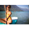 SUP Stand up paddle board concept - Pretty, young woman paddle boarding on a lovely lake in warm late afternoon light - shot from underwater