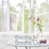 3d Breathe In Breathe Out Text on small living room side table in light soft home environment with windows open.