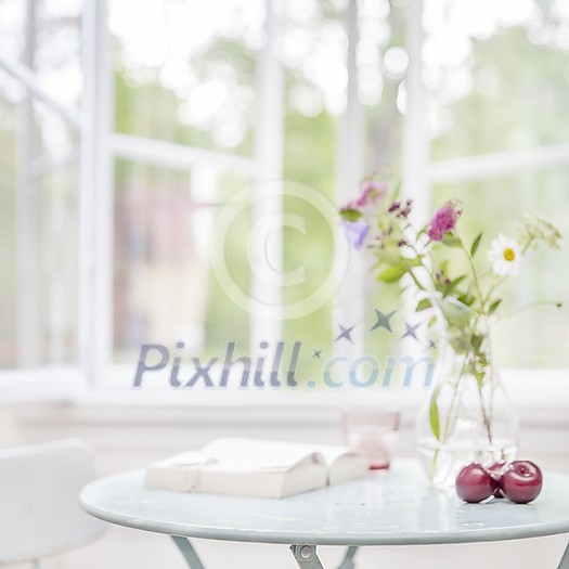 Small living room side table with focus in the front of the table with space for text, and out of focus light soft home environment.