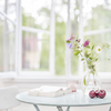 Small living room side table with focus in the front of the table with space for text, and out of focus light soft home environment.