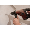 young professional construction worker drilling holes in the bathroom wall for installing bathroom accessories