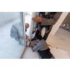 professional carpenters installing a balcony door in a new apartment with panoramic windows