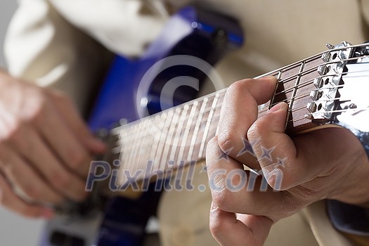 Close up of male hands playing electric guitar