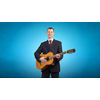 Young man in black suit playing acoustic guitar