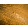 Aerial view of a tractor working a field after harvest