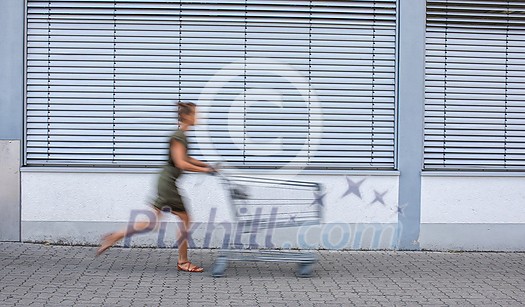 Pretty, young woman going grocery shopping with a trolley Pretty, young woman going grocery shopping with a trolley